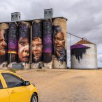 Brightly coloured painting of 4 Australian Aboriginals on concrete grain silos