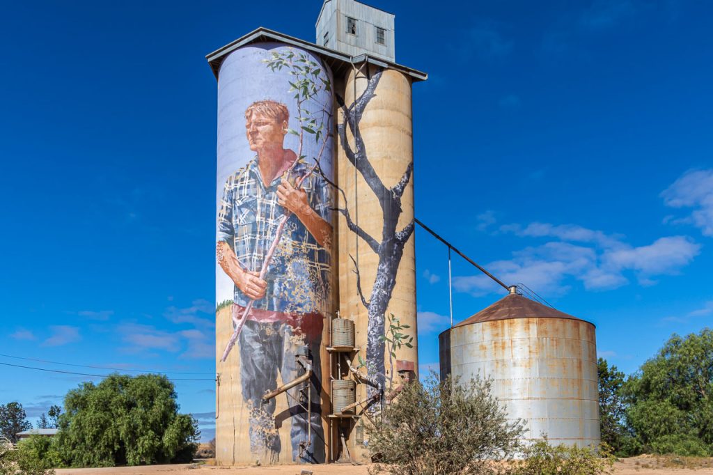 Coloured painting of a young man on outdoor concrete grain silo