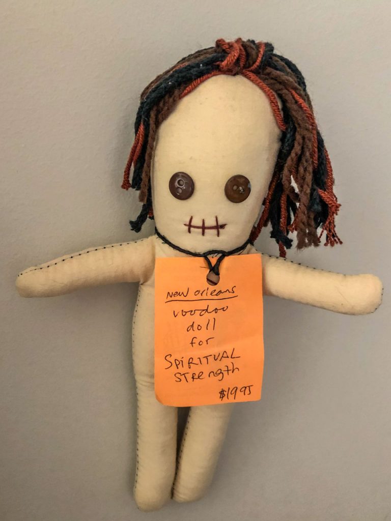 A cloth doll with button eyes, a stitched mouths and wool hair