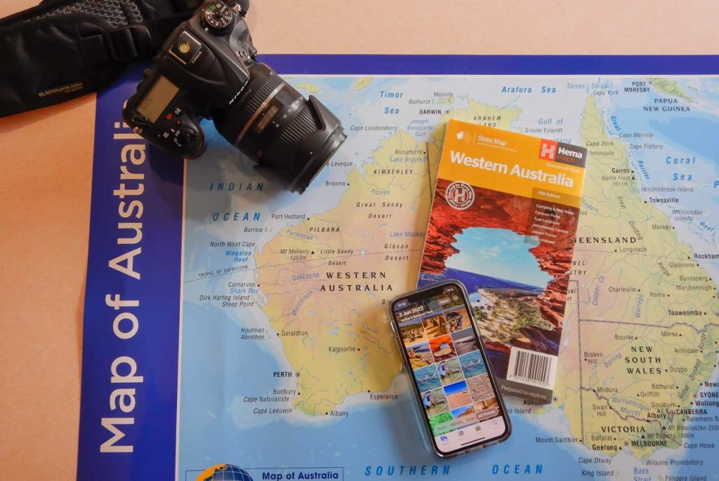 A camera, a mobile phone, map of Australia, and cover of a map of Western Australia