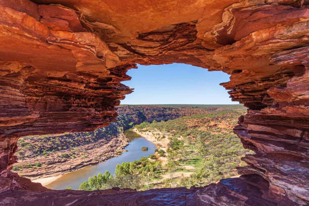A river is seen through a hole in the cliff