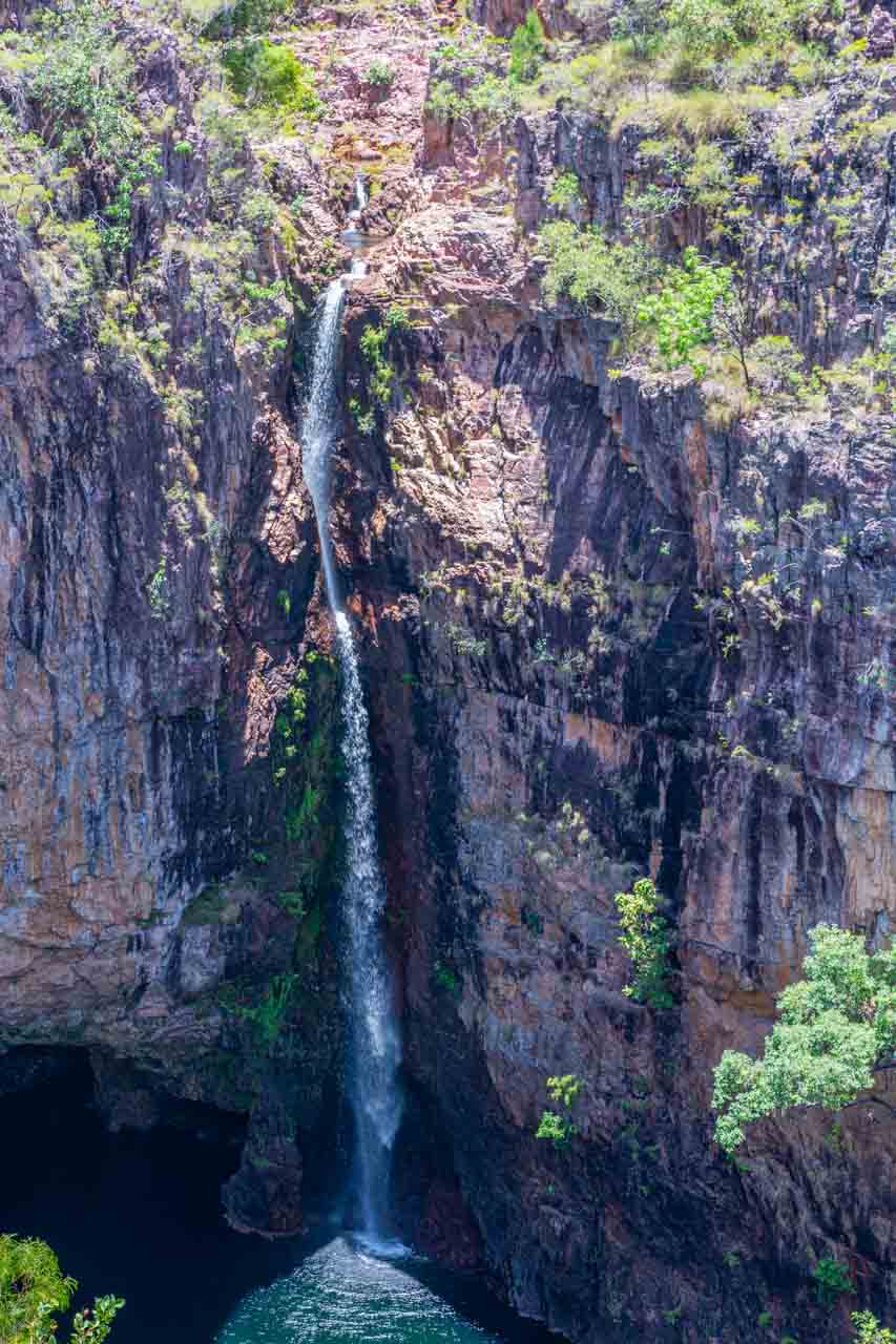 A narrow waterfall drops over the escarpment into a pool below.