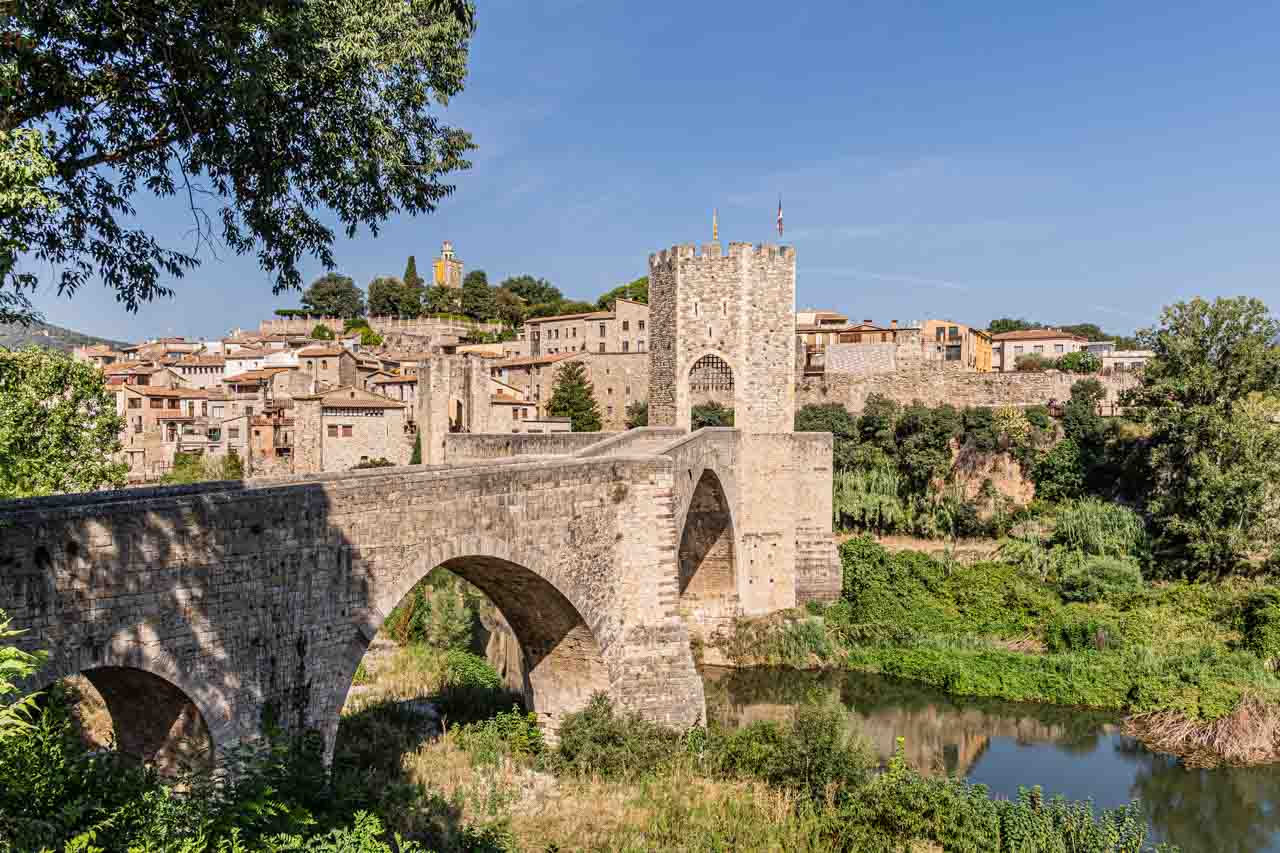 A view of a town made of stone buildings and a stone bridge built in medieval times.