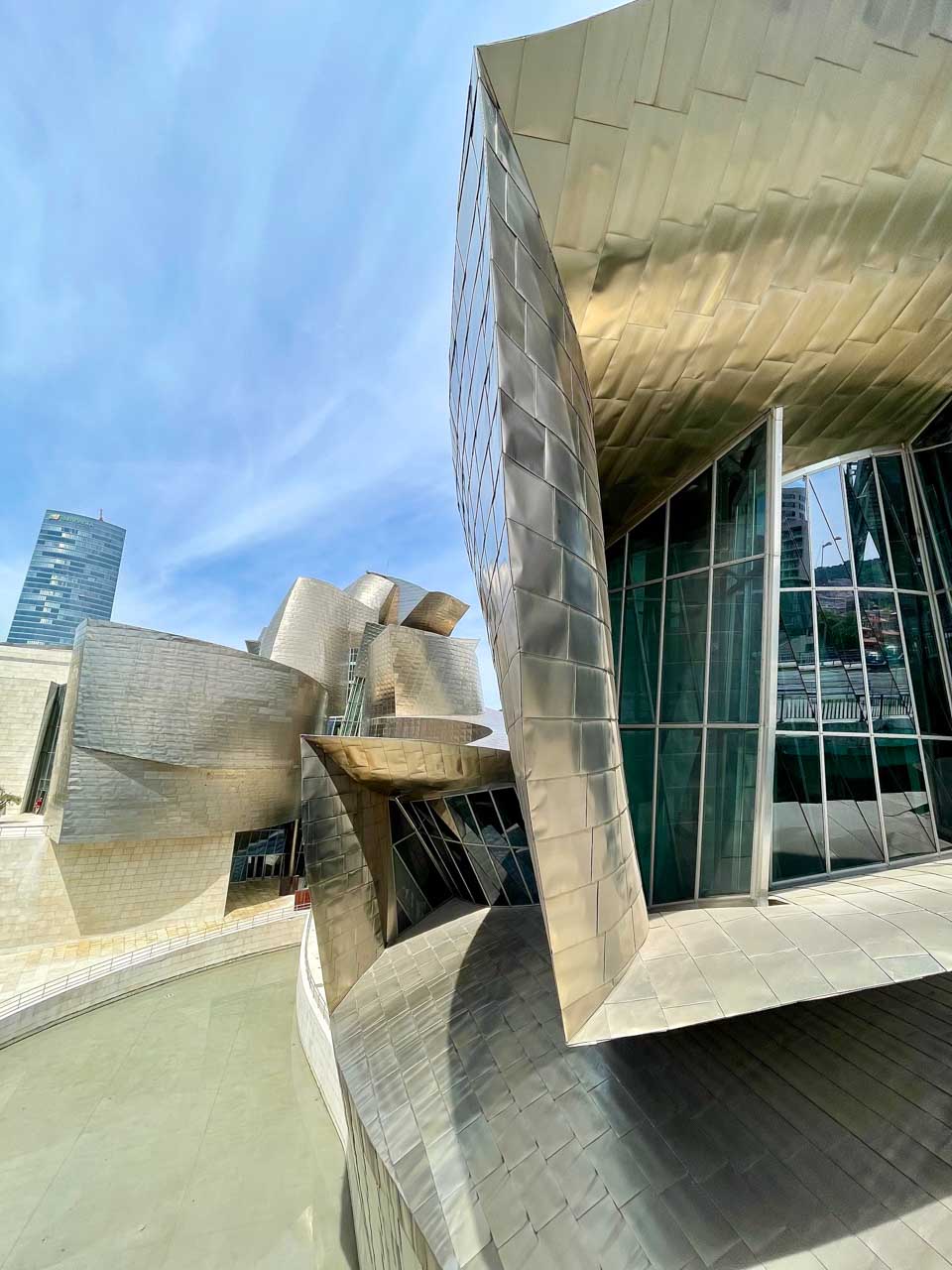 The silver-tiled side facade of the Bilbao Guggenheim Museum.