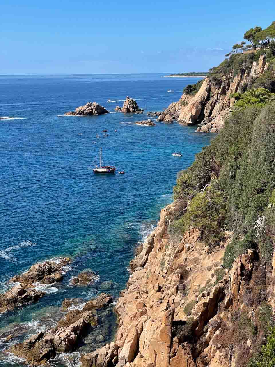 The ruggered coastline of southern Spain on the Mediterranean. Boats are moored near the rocky cliffs.