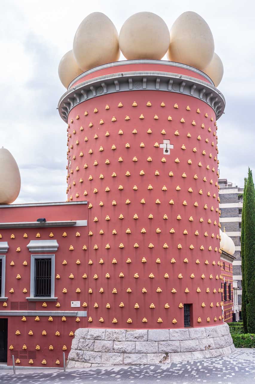 A red painted tower decorated with yellow knobs and topped with large eggs shapes.