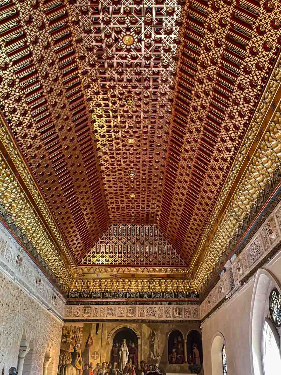 A room with an ornately decorated wooden ceiling.
