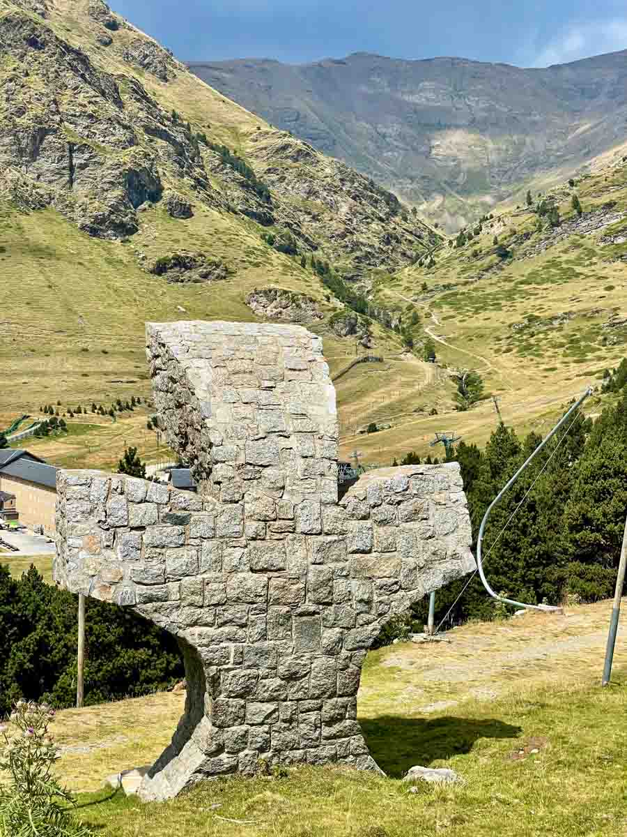 A stone cross on a hill faces the valley below.