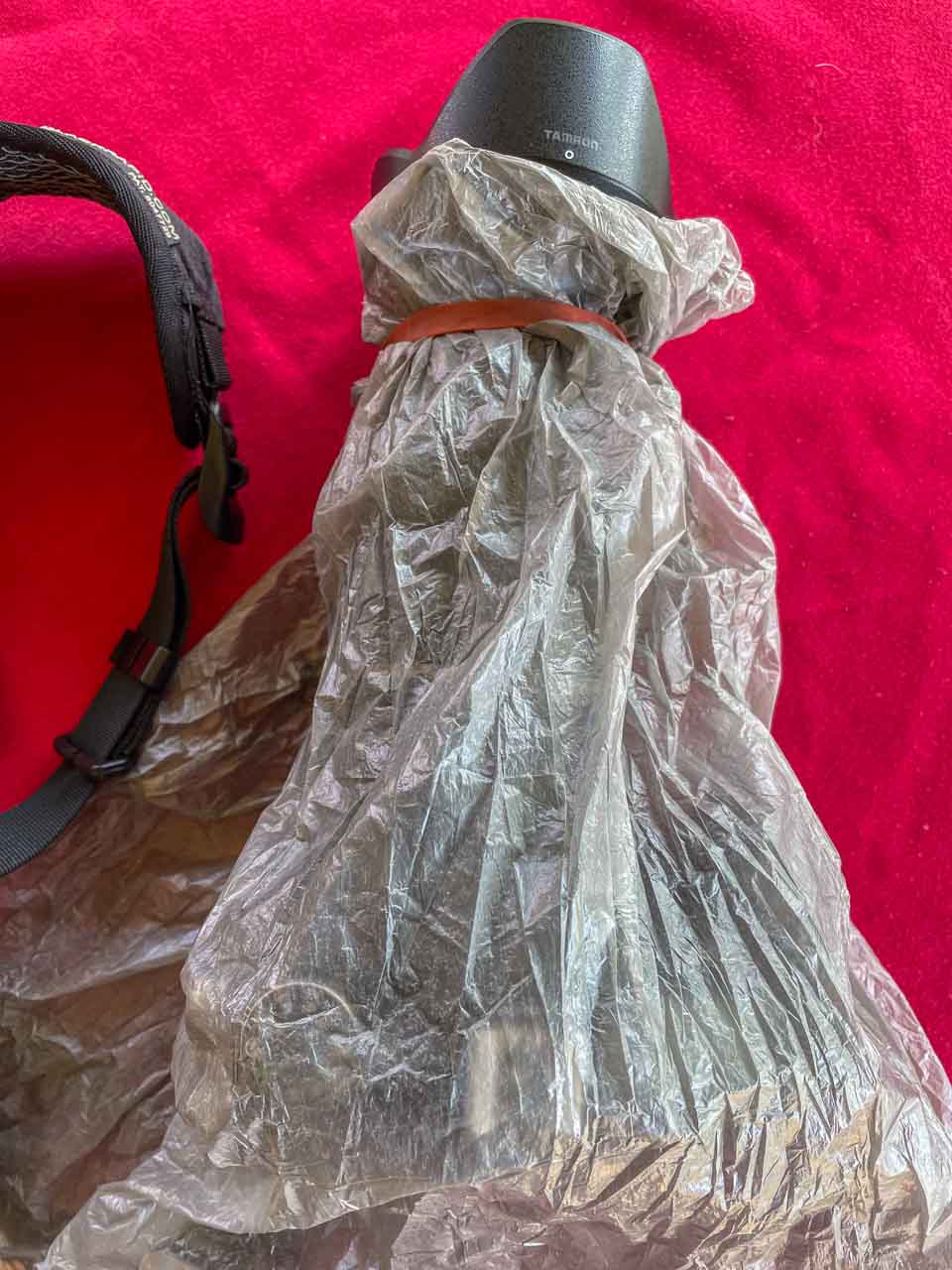 A plastic bag covers a camera to prevent it getting wet in the rain.